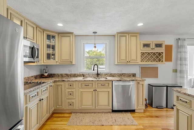 9 Indian Rock Dr, Saugus, MA 01906 - kitchen featuring cream cabinetry, stainless steel appliances, a sink, light wood-style floors, and light stone countertops