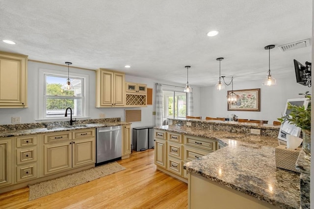 9 Indian Rock Dr, Saugus, MA 01906 - kitchen featuring stainless steel dishwasher, cream cabinets, a sink, light wood-style floors, and a textured ceiling