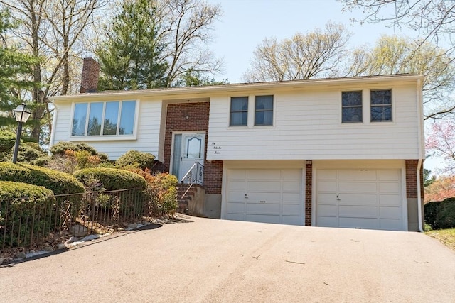 24 Charles Dr, Canton, MA 02021 - raised ranch with a chimney, a garage, brick siding, and driveway