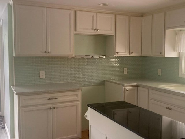 44 Tallawanda Rd, Swansea, MA 02777 - kitchen with decorative backsplash, a sink, and white cabinets