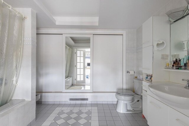 bathroom with tile patterned floors, vanity, toilet, and visible vents