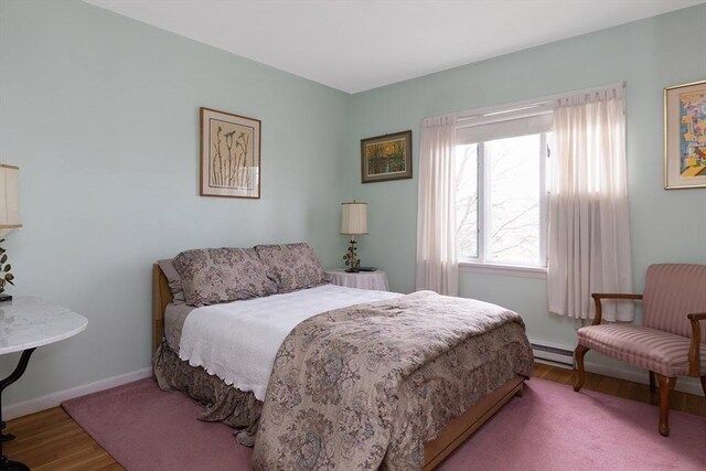 bedroom featuring baseboards, a baseboard radiator, and wood finished floors