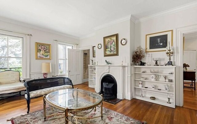 living area featuring hardwood / wood-style flooring and ornamental molding