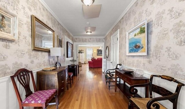 hall with light hardwood / wood-style floors and ornamental molding