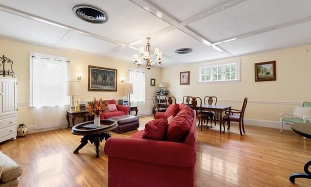 living room with hardwood / wood-style flooring, plenty of natural light, coffered ceiling, and a notable chandelier