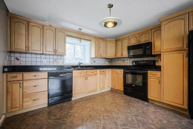 kitchen featuring dark countertops, black appliances, tasteful backsplash, and a sink