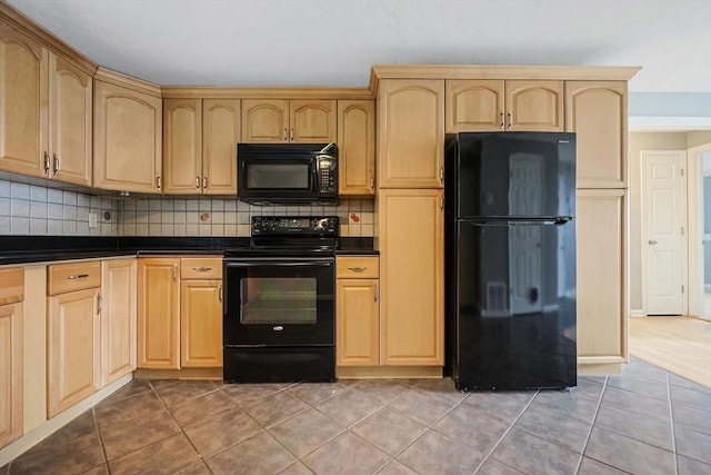 kitchen featuring light tile patterned floors, light brown cabinets, black appliances, dark countertops, and backsplash