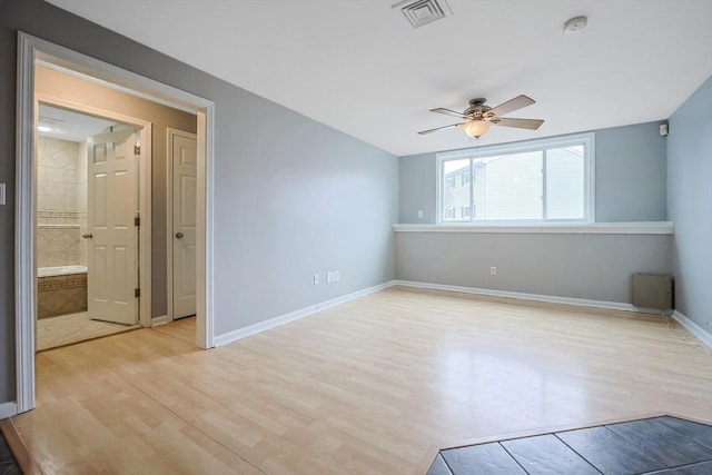 unfurnished room featuring a ceiling fan, baseboards, visible vents, and light wood finished floors