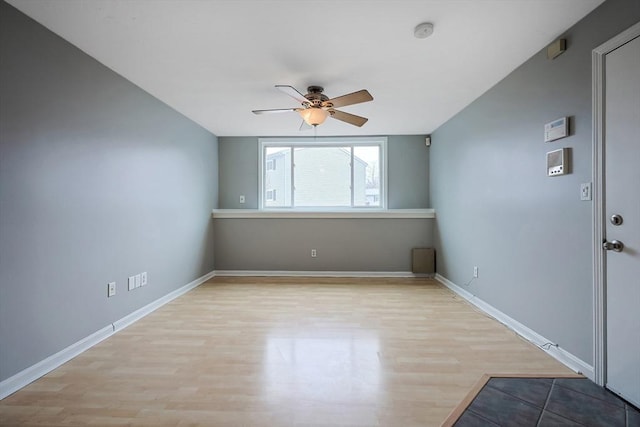 empty room with baseboards, light wood-style floors, and ceiling fan