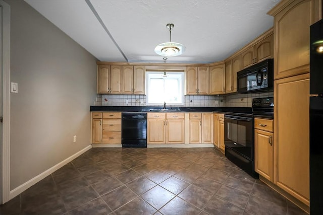 kitchen featuring black appliances, a sink, backsplash, dark countertops, and baseboards