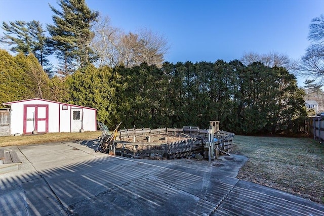 wooden terrace featuring a shed, an outdoor structure, and fence