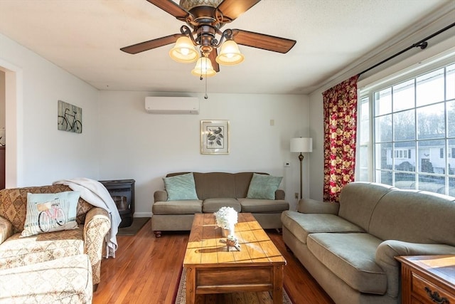 living room featuring a ceiling fan, an AC wall unit, and wood finished floors