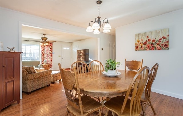 dining area with ceiling fan with notable chandelier, light wood-type flooring, and baseboards