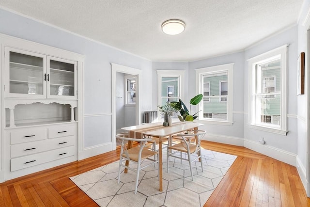 dining room featuring light hardwood / wood-style floors and a textured ceiling