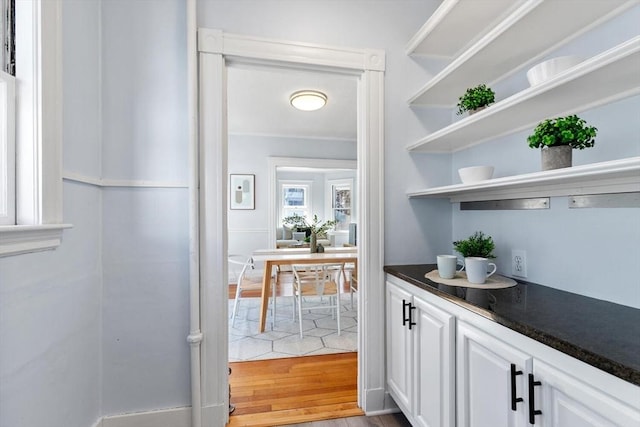 bar featuring white cabinetry and light hardwood / wood-style flooring