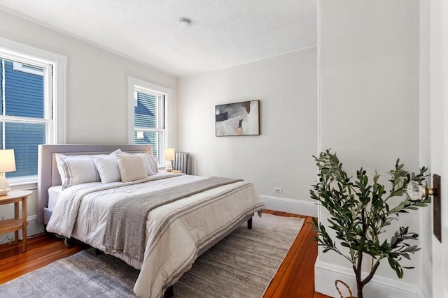 bedroom featuring hardwood / wood-style flooring and radiator