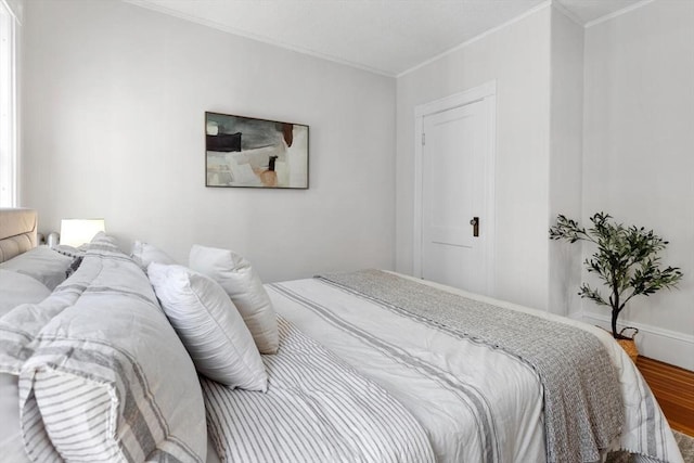 bedroom featuring ornamental molding and hardwood / wood-style floors