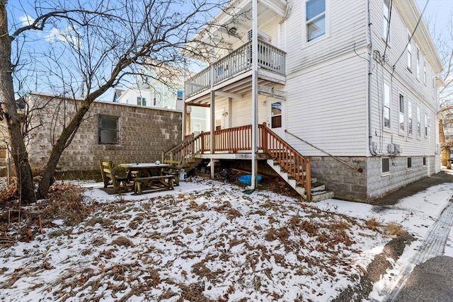 snow covered property featuring a balcony