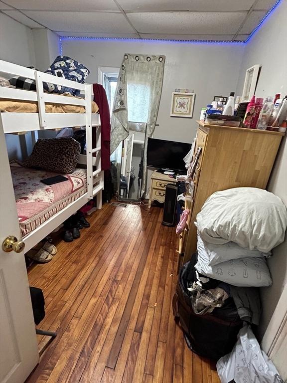 bedroom featuring wood-type flooring and a paneled ceiling