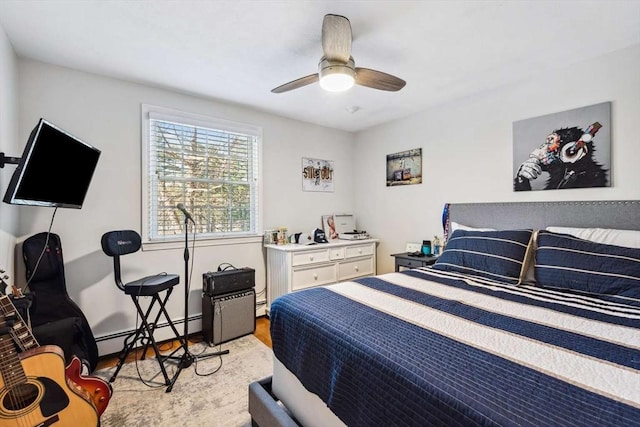 bedroom with ceiling fan, baseboard heating, and light hardwood / wood-style floors