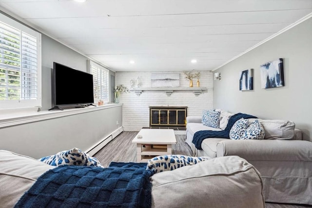 living room with a fireplace, baseboard heating, plenty of natural light, and hardwood / wood-style flooring