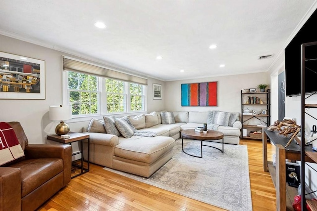 living room with baseboard heating, wood-type flooring, and crown molding