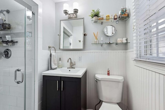 bathroom with toilet, a shower with door, and vanity