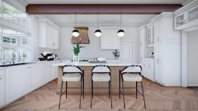 kitchen featuring white cabinets, light parquet flooring, hanging light fixtures, and a kitchen island