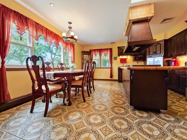 dining area with light tile patterned floors and a chandelier