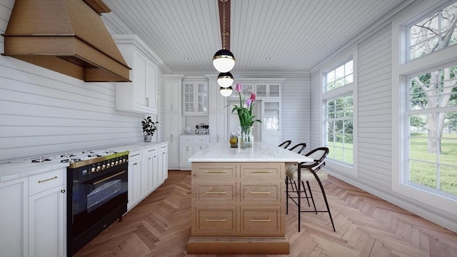 kitchen featuring white cabinets, custom exhaust hood, and a kitchen island