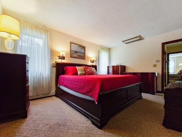 carpeted bedroom featuring a baseboard radiator and a textured ceiling