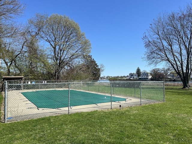 view of pool featuring a lawn, fence, and a fenced in pool