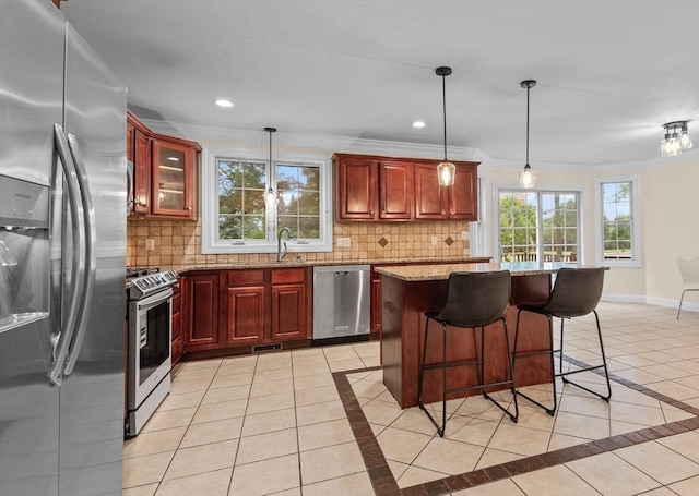 kitchen featuring light tile patterned flooring, decorative light fixtures, stainless steel appliances, light stone countertops, and backsplash