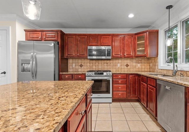 kitchen featuring sink, appliances with stainless steel finishes, tasteful backsplash, light tile patterned flooring, and decorative light fixtures