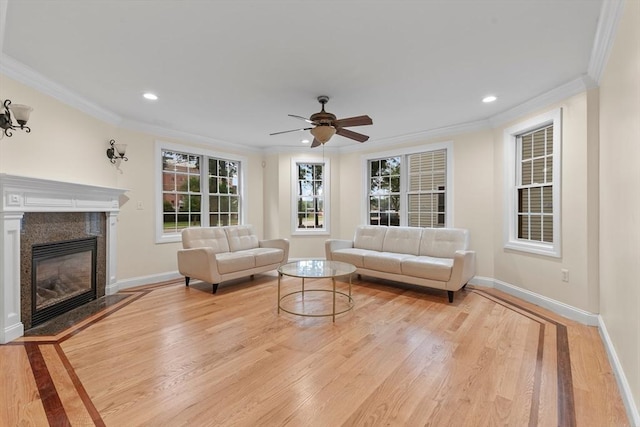 living room with ceiling fan, ornamental molding, and light hardwood / wood-style flooring