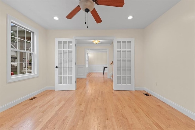 spare room with ceiling fan, light wood-type flooring, and french doors