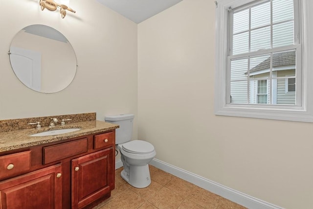 bathroom with vanity, a wealth of natural light, tile patterned floors, and toilet