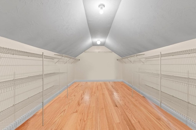 walk in closet featuring wood-type flooring and lofted ceiling