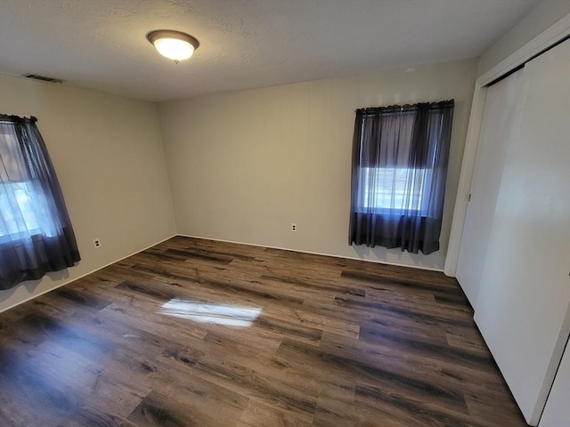 unfurnished room with dark hardwood / wood-style floors and a textured ceiling