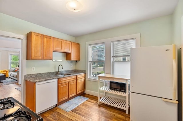 111 Williams St Unit 1, Boston, MA 02130 - kitchen with white appliances, a sink, light wood-style flooring, and baseboards
