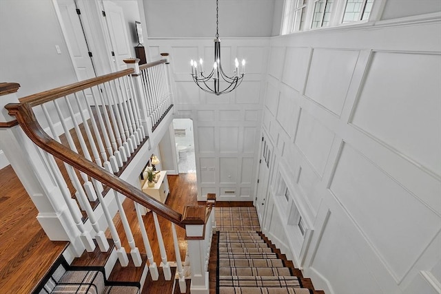 159 Marked Tree Rd, Needham, MA 02492 - stairway featuring a decorative wall, a chandelier, and wood finished floors