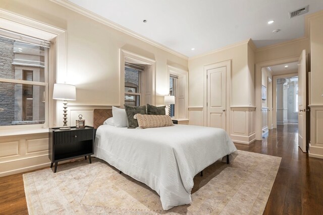 bedroom featuring wood-type flooring and ornamental molding