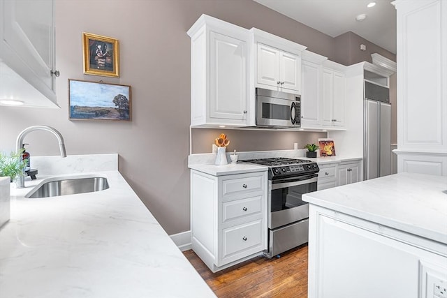 8 Garrison St Unit 104, Boston, MA 02116 - kitchen with appliances with stainless steel finishes, a sink, dark wood-style floors, white cabinets, and light stone countertops
