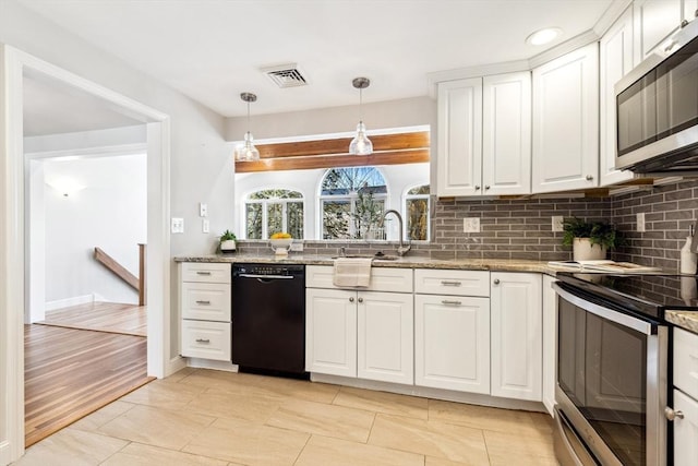 kitchen featuring appliances with stainless steel finishes, pendant lighting, white cabinets, and light stone counters