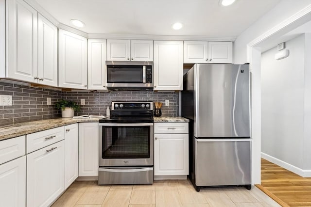 kitchen featuring white cabinetry, appliances with stainless steel finishes, and light stone countertops