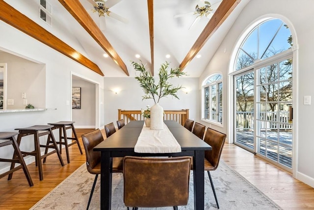 dining space with beamed ceiling, ceiling fan, and light hardwood / wood-style floors