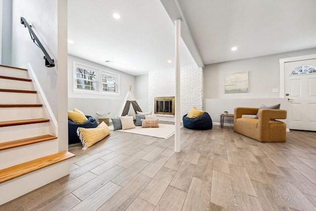 interior space featuring a brick fireplace and light hardwood / wood-style flooring