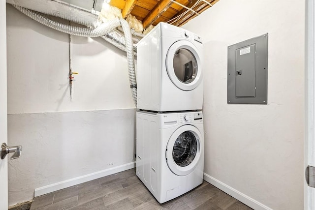 washroom featuring stacked washer / drying machine, wood-type flooring, and electric panel