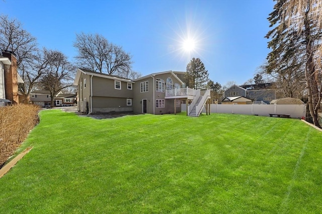 rear view of house featuring a wooden deck and a yard