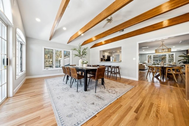 dining area featuring lofted ceiling with beams and light hardwood / wood-style flooring